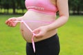 Close-up of pregnant woman mother belly, she is using a ruler to measure waistline keep healthy do exercise Royalty Free Stock Photo