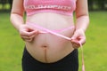 Close-up of pregnant woman mother belly, she is using a ruler to measure waistline keep healthy do exercise Royalty Free Stock Photo