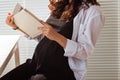 Close-up of pregnant woman reading book at home. Morning and pregnancy concept Royalty Free Stock Photo