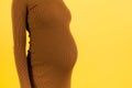 Close up of pregnant woman`s abdomen at blue background. Girl is wearing white underwear. Maternity concept. Copy space Royalty Free Stock Photo