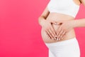 Close up of pregnant woman`s belly with heart made of fingers at pink background. Maternity concept. Love to the future baby. Cop Royalty Free Stock Photo