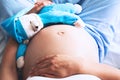 Close-up pregnant woman`s belly with teddy toy bear. Royalty Free Stock Photo