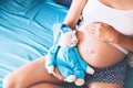 Close-up pregnant woman`s belly with teddy toy bear. Royalty Free Stock Photo