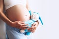 Close-up pregnant woman`s belly with teddy toy bear. Royalty Free Stock Photo