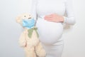 Close-up pregnant woman's belly with teddy toy bear. Pregnancy, parenthood, preparation and expectation concept.  Pregnancy woman Royalty Free Stock Photo