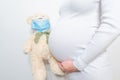 Close-up pregnant woman's belly with teddy toy bear. Pregnancy, parenthood, preparation and expectation concept.  Pregnancy woman Royalty Free Stock Photo