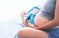 Close-up pregnant woman`s belly with teddy toy bear. Royalty Free Stock Photo