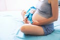 Close-up pregnant woman`s belly with teddy toy bear. Royalty Free Stock Photo