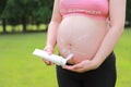 Close-up of pregnant woman mother belly, apply lotion prevent stretch marks over grass lawn meadow sunset outdoor nature summer