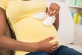 Pregnant Woman Holding Baby Shoes Royalty Free Stock Photo