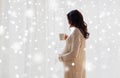 Close up of pregnant woman with tea cup at window Royalty Free Stock Photo