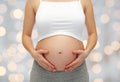 Close up of pregnant woman touching her bare tummy Royalty Free Stock Photo