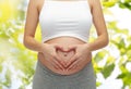 Close up of pregnant woman touching her bare tummy Royalty Free Stock Photo