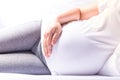 Close up pregnant women lying and touching her belly with hands on her bed