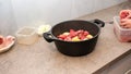 Young woman cooking at home. Fresh raw ingredients beef soup in a large pot. Royalty Free Stock Photo