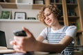 Close-up of pretty curly schoolgirl e-learning, doing homework remotely, preparing for test, tutoring online from home Royalty Free Stock Photo