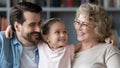 Close up pretty little girl hugging father and grandmother Royalty Free Stock Photo