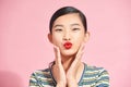 Close up of a pretty smiling young asian woman wearing casual clothes standing isolated over pink background, sending kiss Royalty Free Stock Photo