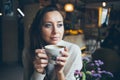 Close-up of pretty woman drinking cup of coffee in autumn / winter evening day. Royalty Free Stock Photo