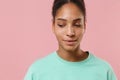 Close up of pretty young african american woman girl in green sweatshirt posing isolated on pastel pink wall background Royalty Free Stock Photo