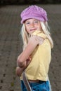 Close up of pretty young blonde hippie girl in pink hat and attitude