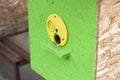 Close-up of primitive beehive painted bright green and yellow with brown golden bees on blurred sunny summer copy space background