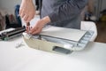 printer repair technician. A male handyman inspects a printer before starting repairs in a client's apartment.