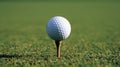 Close up of a pristine white golf ball on a tee with a blurred green background for dramatic effect Royalty Free Stock Photo