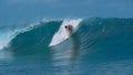 CLOSE UP: Pro male surfer stands up on his surfboard and catches a big wave. Royalty Free Stock Photo