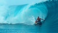 CLOSE UP: Pro surfer riding a big wave drags his hand through the emerald water. Royalty Free Stock Photo