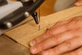 Close-up on the process of sawing wood board on a scroll saw in carpenter workshop Royalty Free Stock Photo