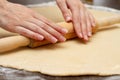 Close up of process woman rolling pin rolls dough on a table with flour Royalty Free Stock Photo