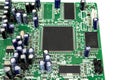 A close-up of the processor microchip surrounded by other electrical components on a green circuit board. Also on the board is a