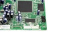 A close-up of the processor microchip surrounded by other electrical components on a green circuit board. Also on the board is a