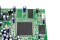 A close-up of the processor microchip surrounded by other electrical components on a green circuit board. Also on the board is a
