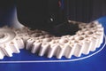 close up on production process of two helical gears by a 3D-printer from white plastic filament on blue taped build plattform Royalty Free Stock Photo