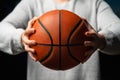 Close up of professional basketball player holding a ball in the hand. Street basketball athlete preparing for competition.