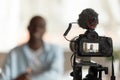 Close up professional camera filming young smiling african american speaker.