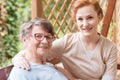 Close-up of a professional caregiver sitting next to and holding