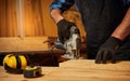 Close up of professional carpenter hands sawing wood with an electric jigsaw in the carpentry workshop Royalty Free Stock Photo