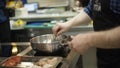 Close-up of professional chef frying in pan in kitchen. Action. Appetizing cooking chef with fried products on fuming