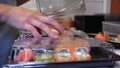 Close-up of professional chef`s hands in transparent gloves making sushi and rolls in a restaurant kitchen. Japanese traditional f Royalty Free Stock Photo