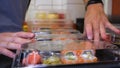 Close-up of professional chef`s hands in transparent gloves making sushi and rolls in a restaurant kitchen. Japanese traditional f Royalty Free Stock Photo