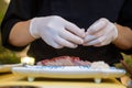 Close-up of professional chef`s hands in white gloves making sushi Royalty Free Stock Photo