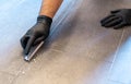 Close up of professional cleaner cleaning grout with a brush blade and foamy soap on a gray tiled bathroom floor Royalty Free Stock Photo