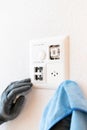 Close up of a professional cleaner cleaning a modern light switch and dimmer and socket Royalty Free Stock Photo