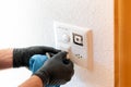 Close up of a professional cleaner cleaning a modern light switch and dimmer and socket Royalty Free Stock Photo