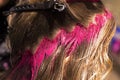Close-up professional coloring strands of blond hair in bright pink color, beauty salon