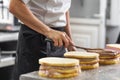 Close up of professional confectioner making a delicious cake in the pastry shop.