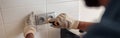 Close up of professional electrician worker with screwdriver is repairing power socket in kitchen Royalty Free Stock Photo